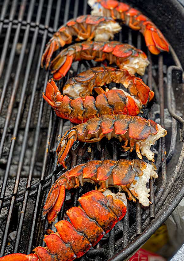 Lobster tail halves grilling meat side facing direct high heat