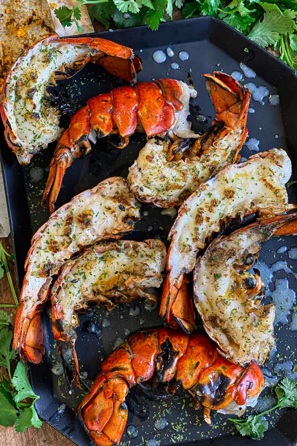 grilled lobster tail halves plated with view of the seared lobster flesh that makes this method tasty