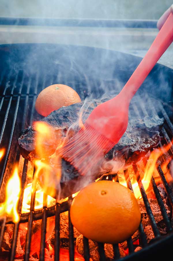 Basting a strip steak with a long handled hi-temp basting brush