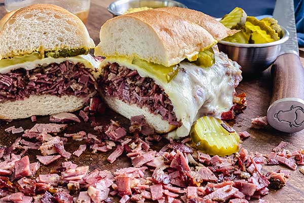 French dip pastrami sandwich on a cutting board