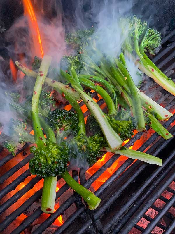 broccolini stalks on a red hot grill