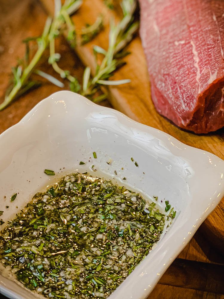 image of rosemary herb paste with eye of round roast in background