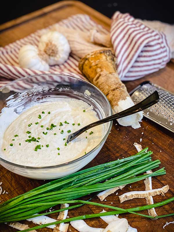 Homemade horseradish sauce in a bowl, surrounded by ingredients