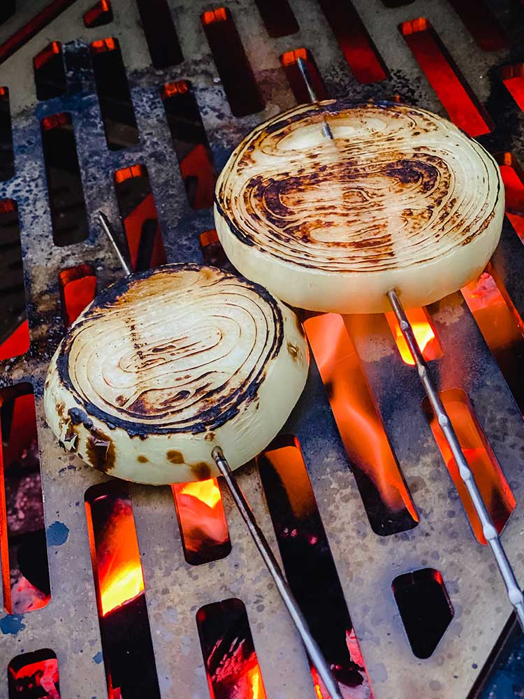 skewered onions on a high flame grill