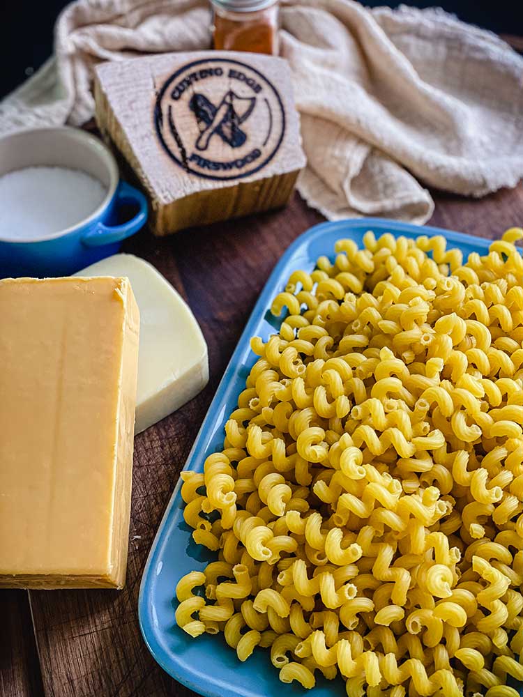 ingredients for mac and cheese including cavatappi pasta, cheddar and Gruyère cheeses, and whipping cream