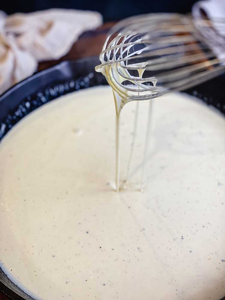 whisking roux and shredded cheeses until melted