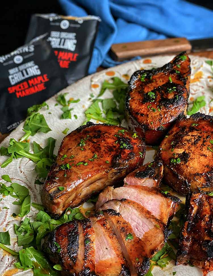 Grilled maple pork chops perfectly seared and sliced on a platter
