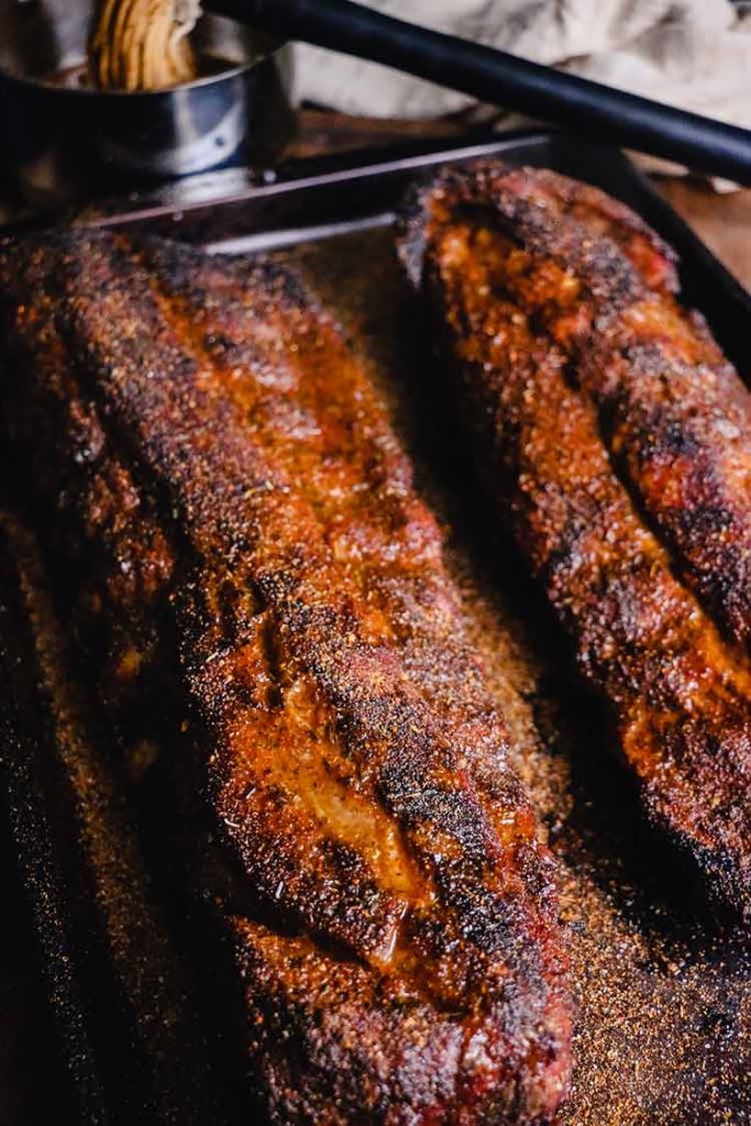 grilled baby back ribs, resting on a cooking sheet