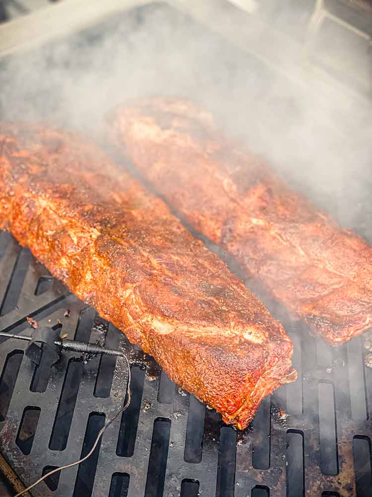 mop sauce causing steam around BBQ ribs on a grill