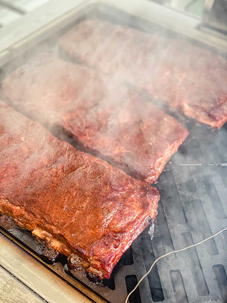 Smoking ribs on the grill with hickory and apple wood chunks of woo