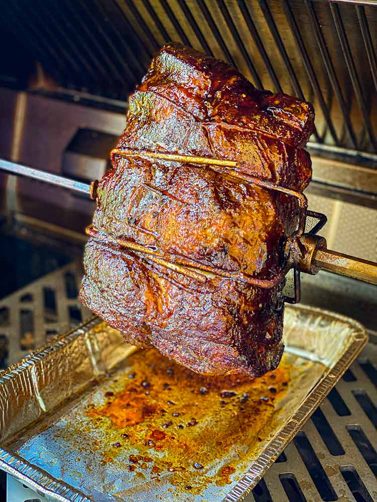 Pork roast on rotisserie coated in mop sauce