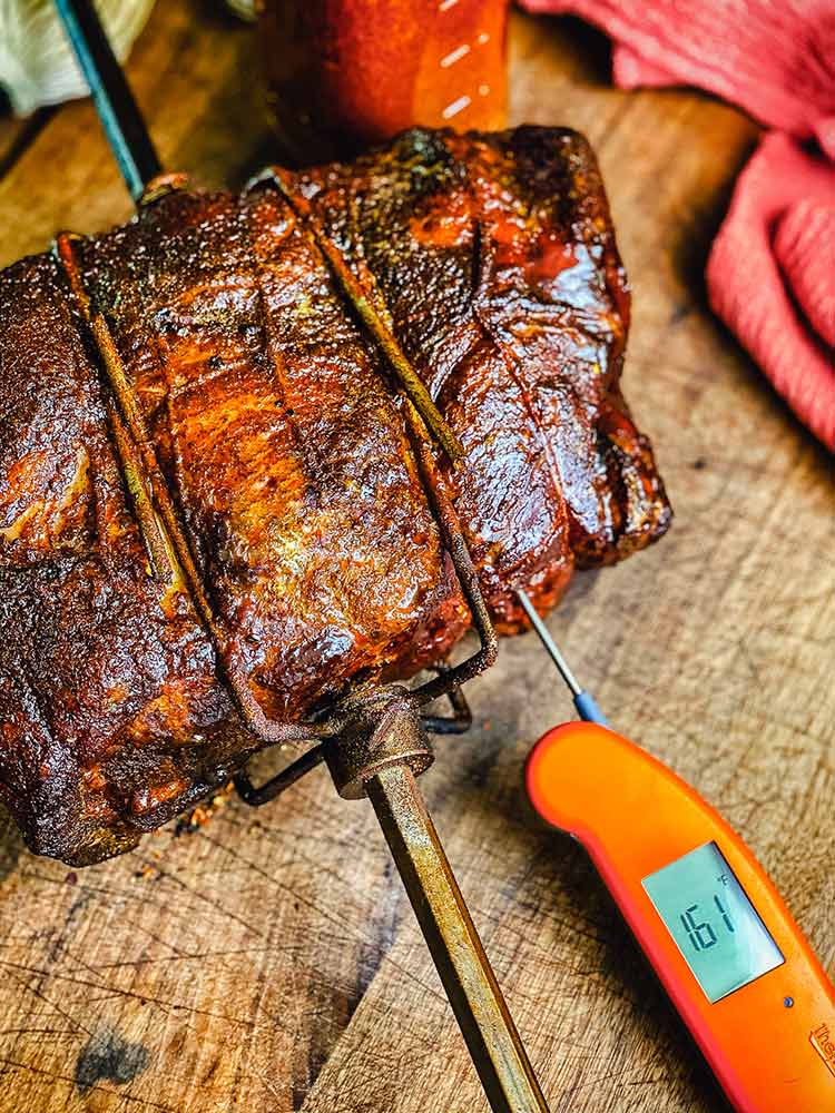 Testing temperature of pork roast with a quick-read thermometer