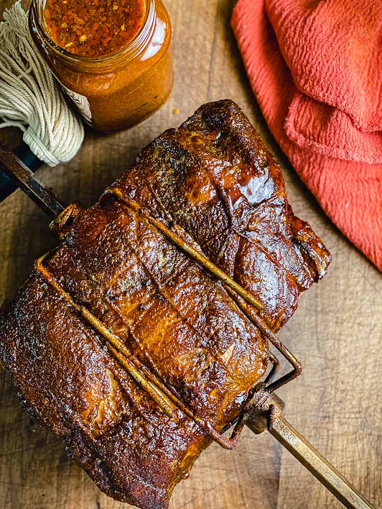 Rotiserie smoked pork resting on wood table