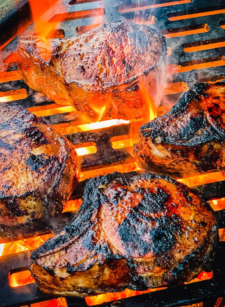 pork chops on grill over charcoal