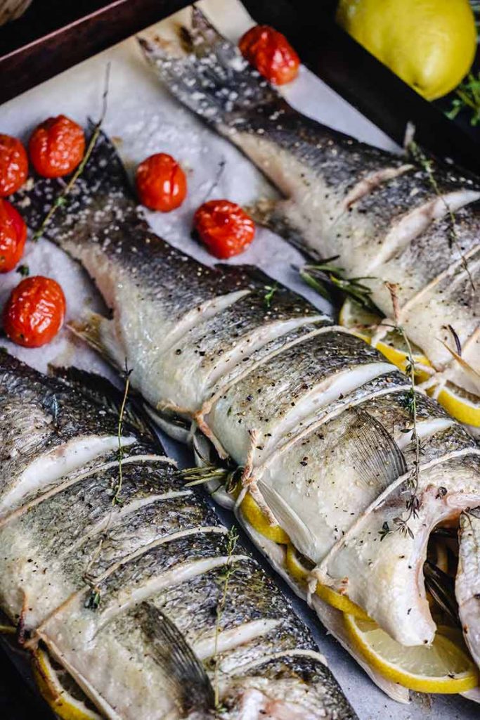 Whole fish, stuffed with lemon and rosemary and tied closed with twine.