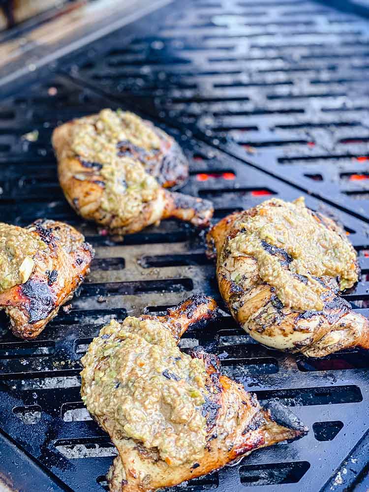 chicken glazed with caribbean jerk sauce on grill over indirect heat.