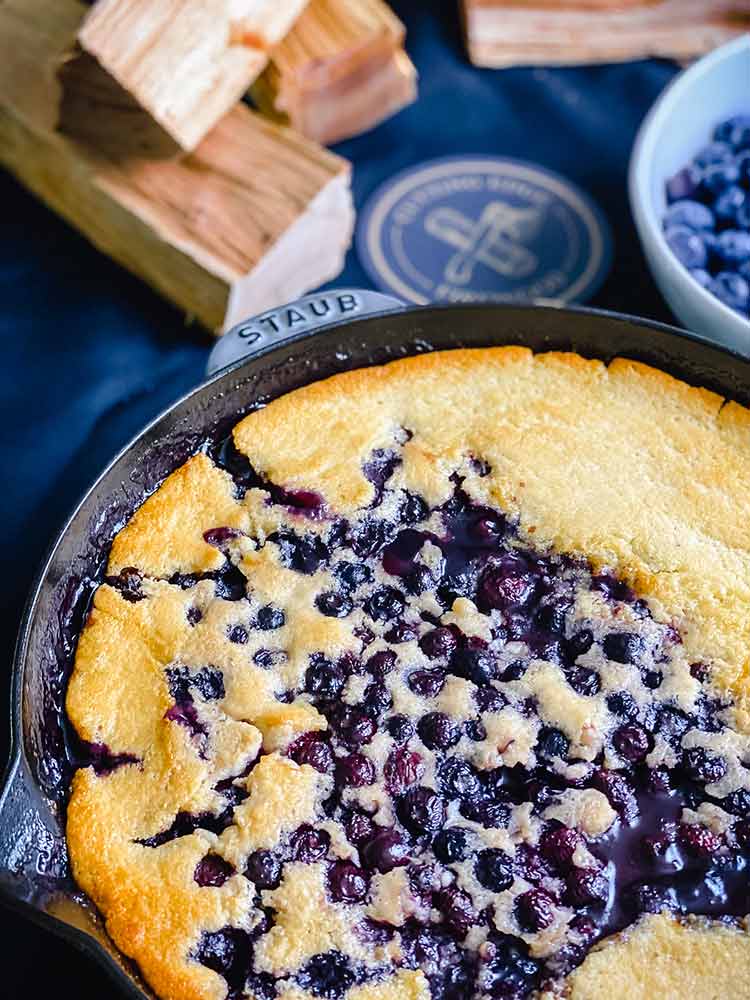 blueberries bubble through the crust of smoked cobbler