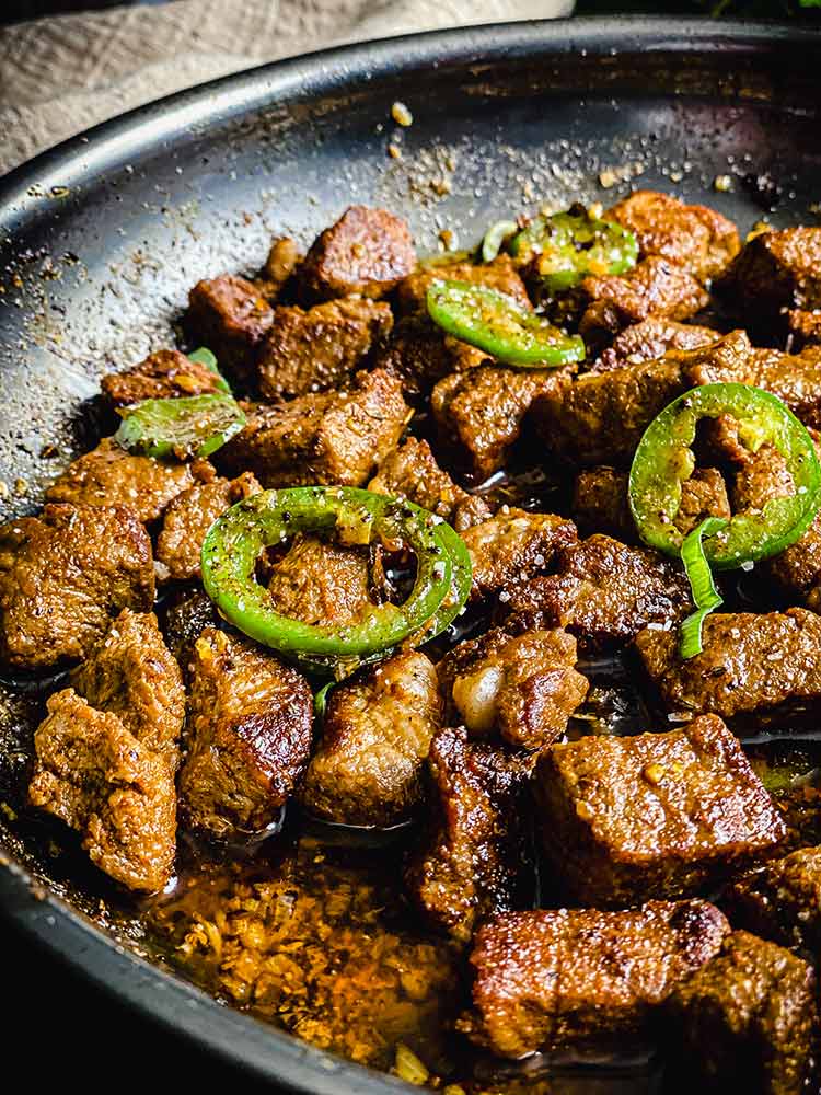 steak with sliced jalepeno and minced garlic, close up 