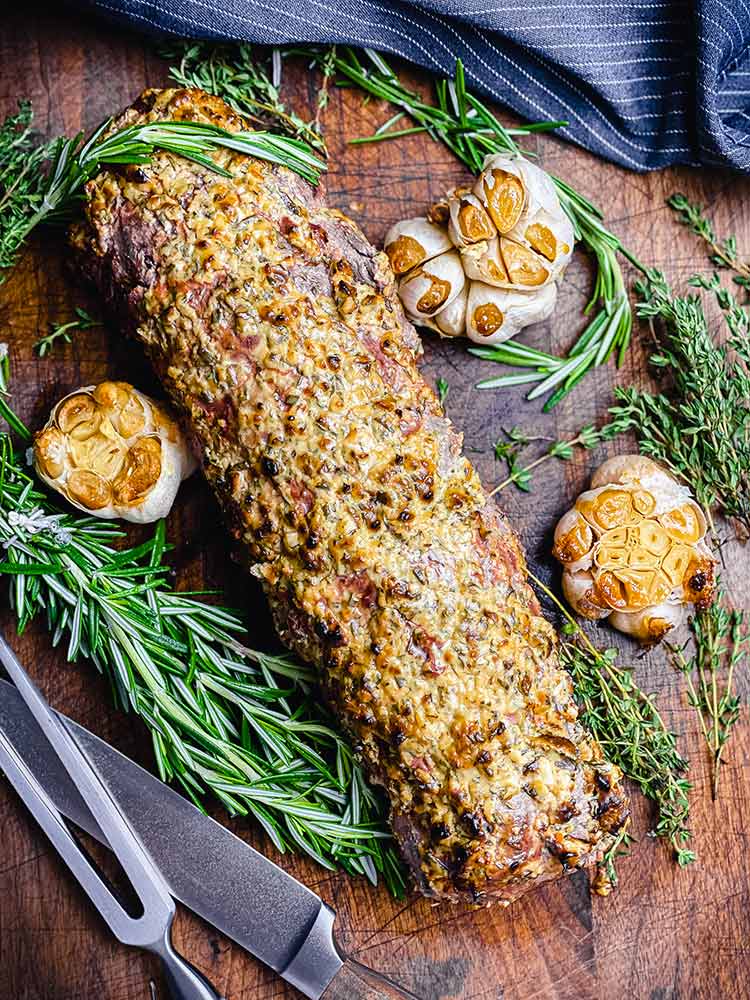 grilled meat and garlic on a cutting board ready to slice