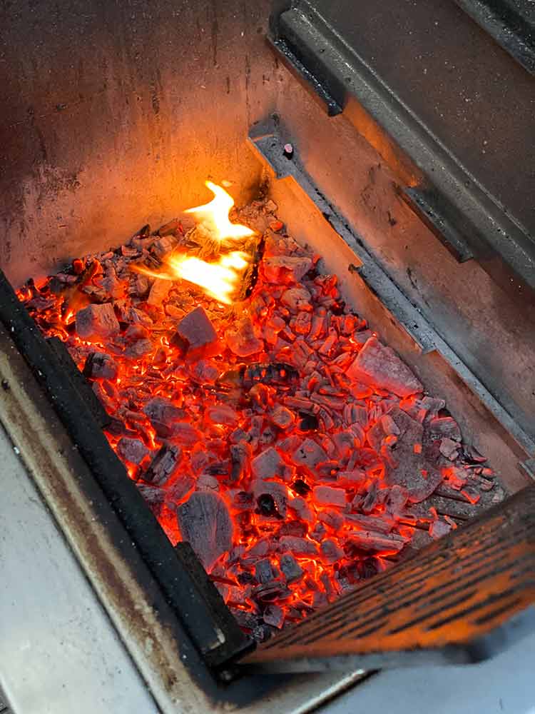 grill with chunks of oak firewood and charcoal 