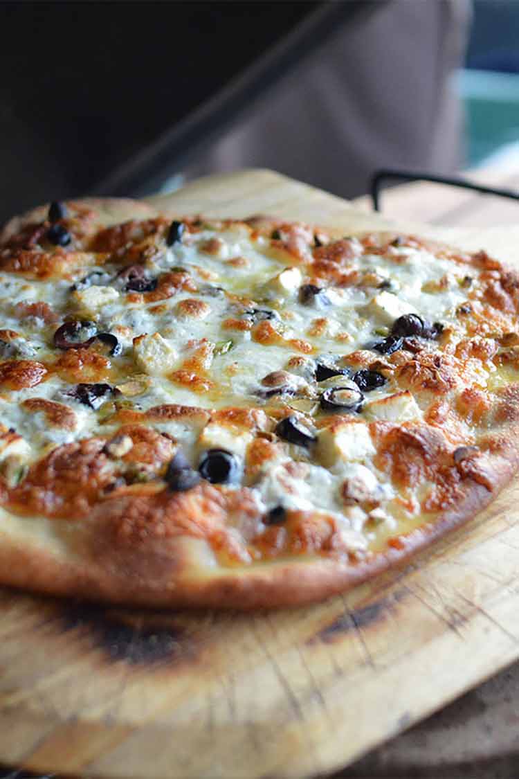 Kamado grilled pizza with olives and mushrooms