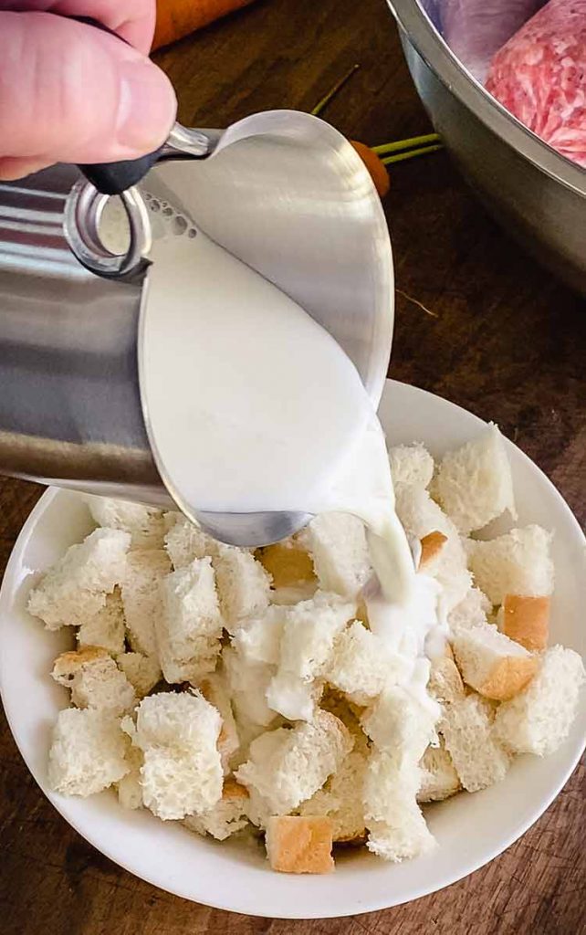 milk being added to a bowl of bread chunks