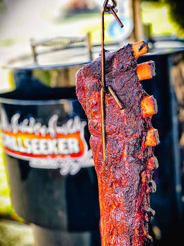 smoked and brined baby back ribs hanging to cool