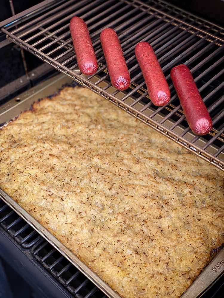 grill with sausages and a pan of sauerkraut