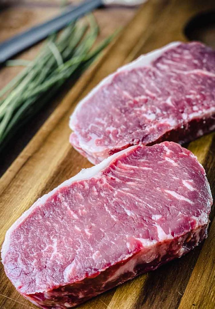 New York strip steak, uniform in size and thickness, trimmed and ready to cook  