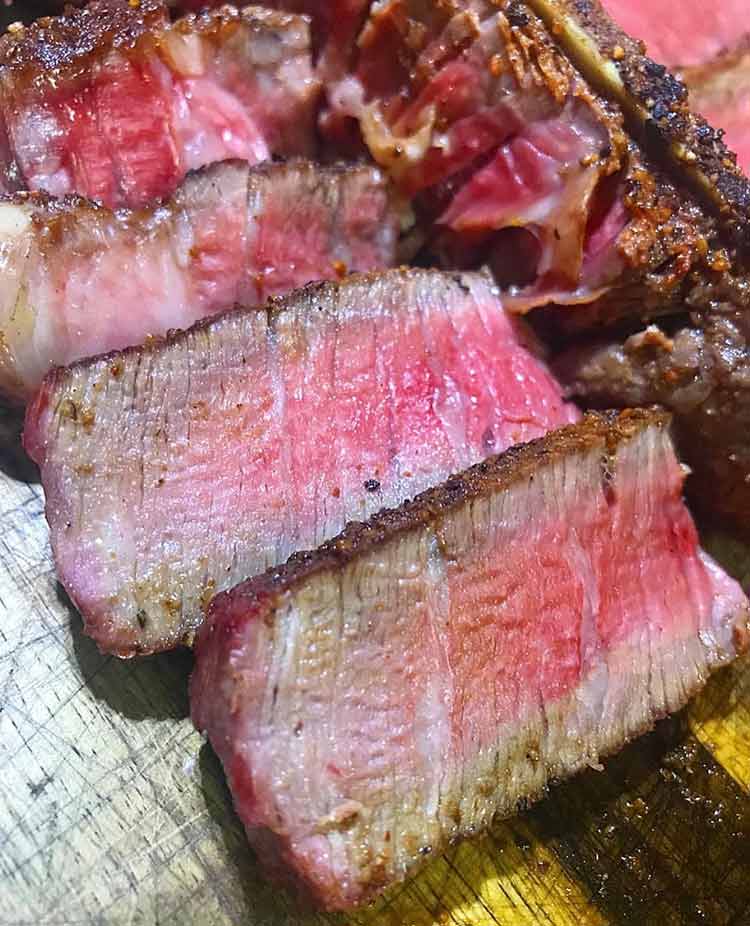 overcooked slices of steak that are crusty on the outside and raw in the middle