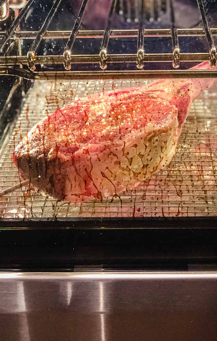 steak on baking rack in oven