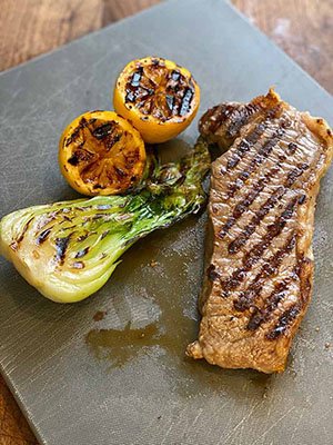 grill marks on bok choy, lemon, and steak