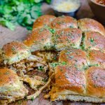 chicken enchilada sliders on cutting board with cheese