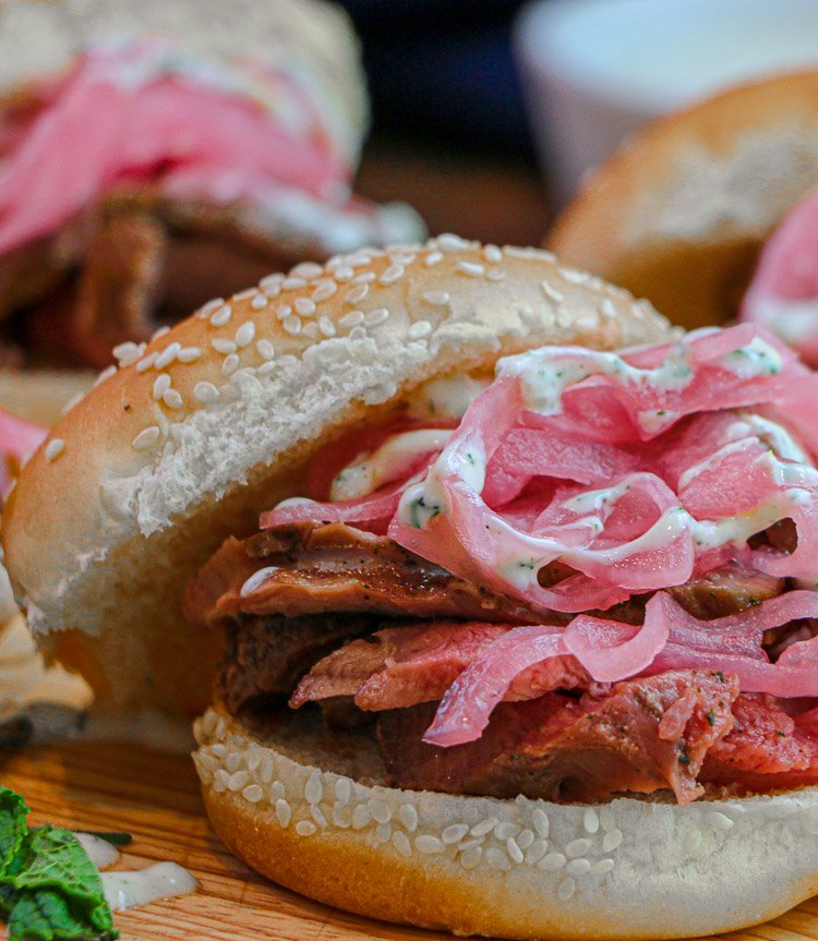 close up of lamb slider on bun with pickled red onions