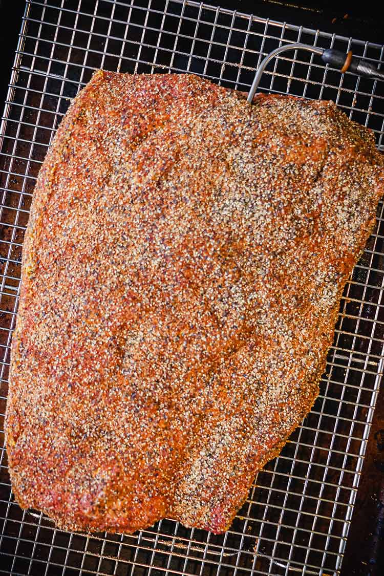 brisket on a rack with thermometer probe in thickest part near the top