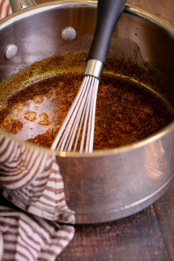 homemade enchilada sauce in a saucepan with whisk