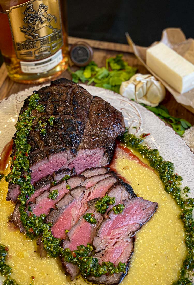 sliced london broil steak with chimichurri