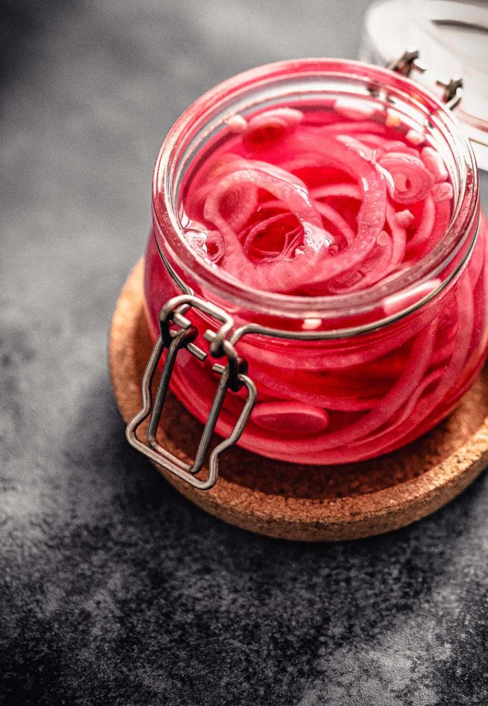 pickled red onions in an open jar