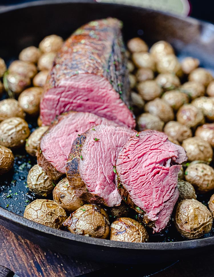 sliced chateaubriand on a bed of potatoes