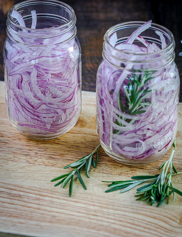 Pickled Red Onion Recipe: Thinly sliced red onions in a jar with or without rosemary, ready for pickling
