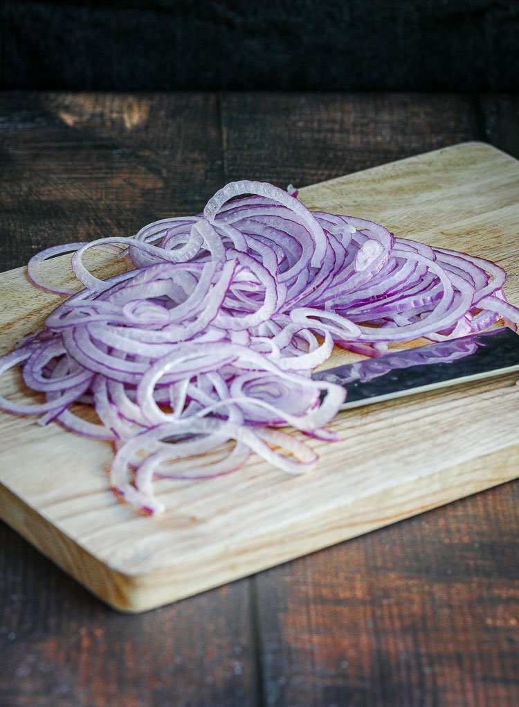 sliced red onions on a cutting board