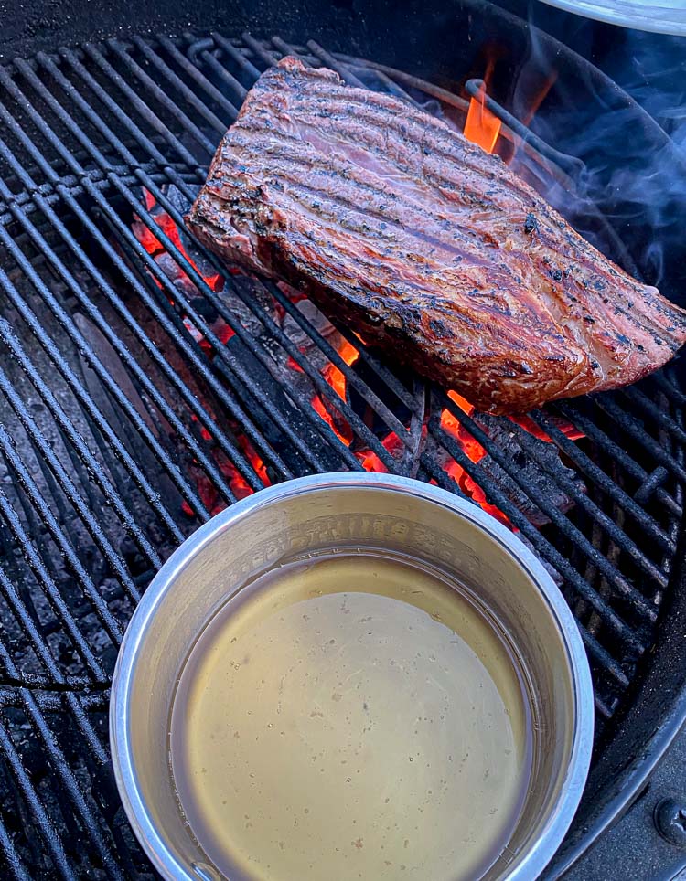 steak on grill over hot coals