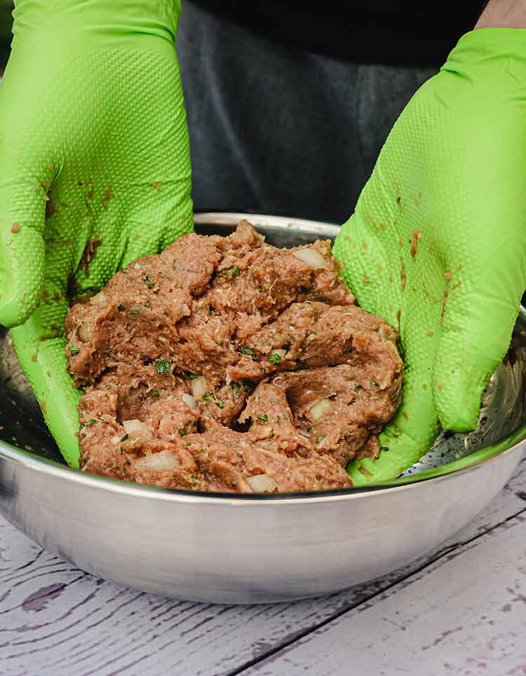 green gloved hands mixing the ingredients