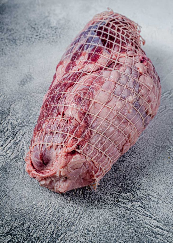uncooked boneless leg of lamb in netting