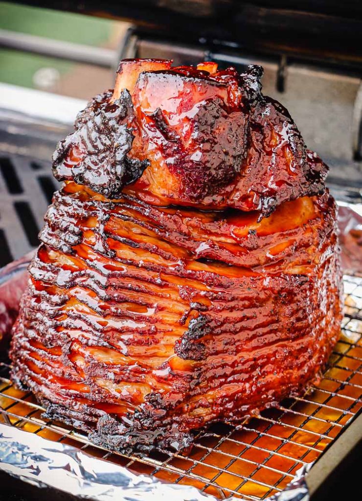 glazed ham smoking on a grill