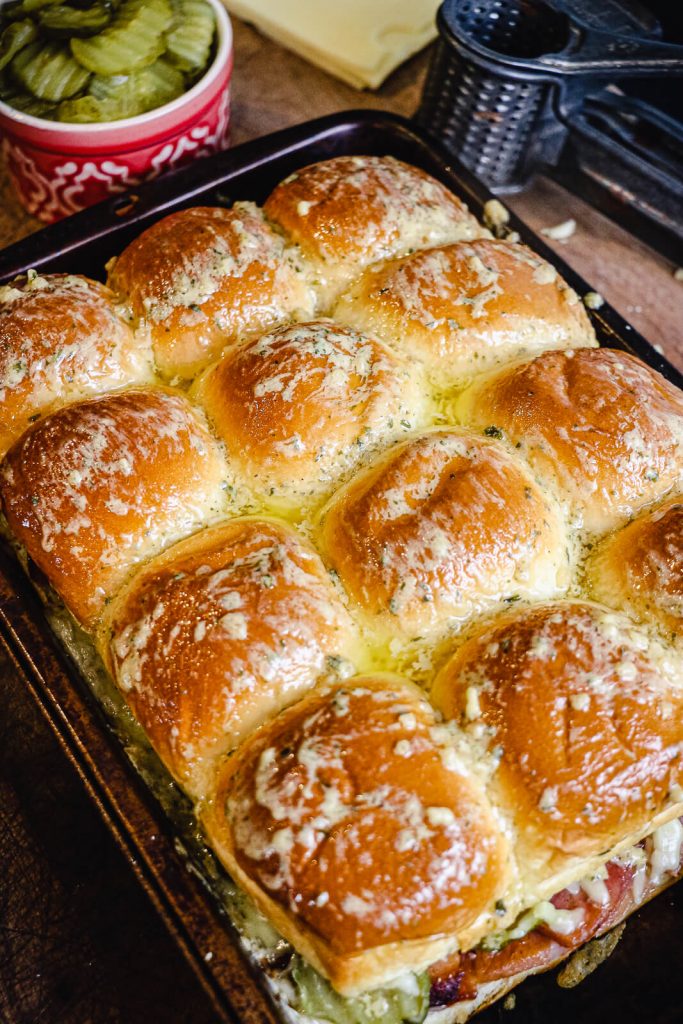 ham and cheese sliders in  pan, topped with dijon butter