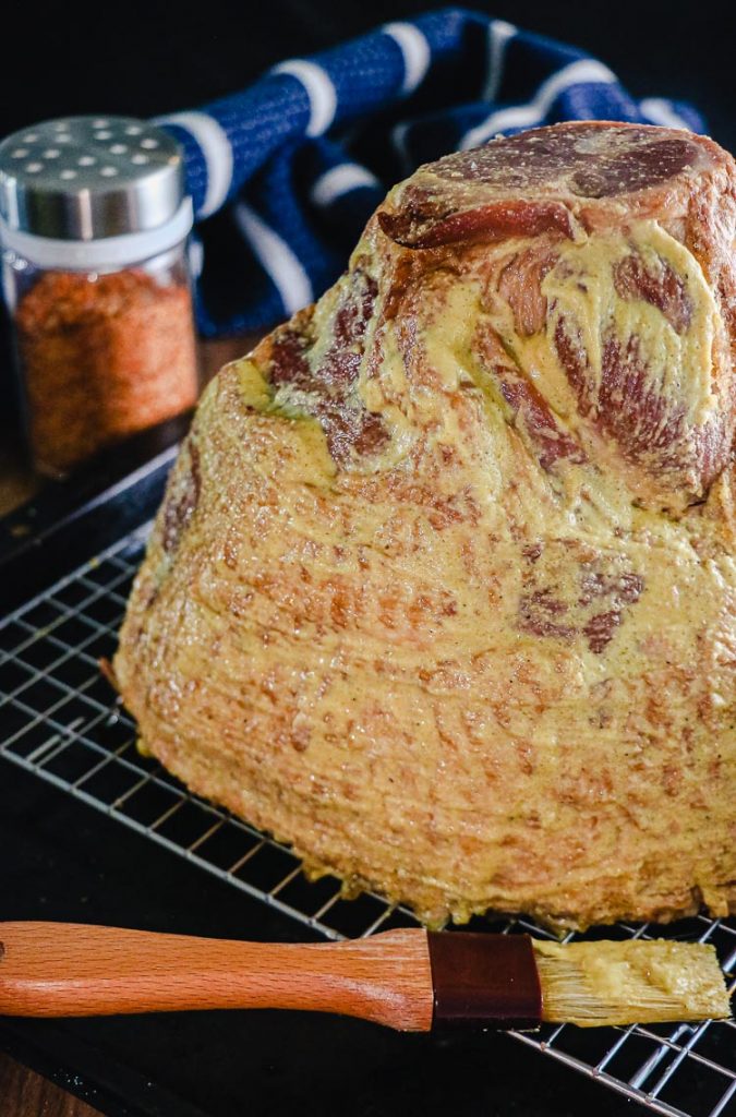 uncooked ham coated in dijon mustard
