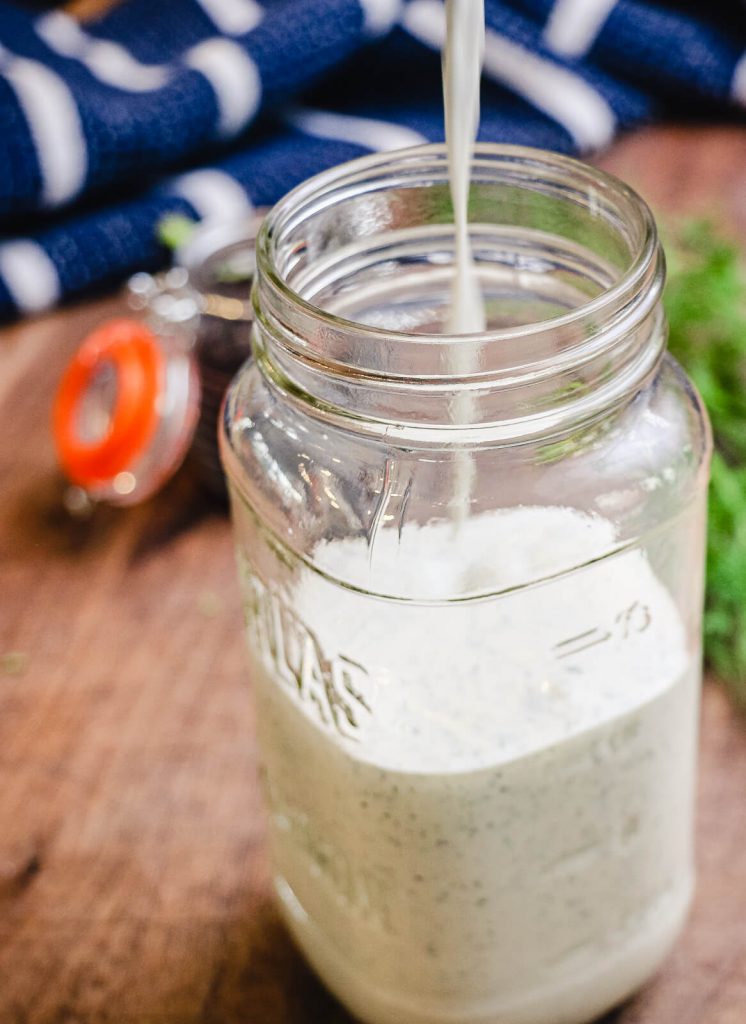 homemade buttermilk ranch being poured into a glass jar