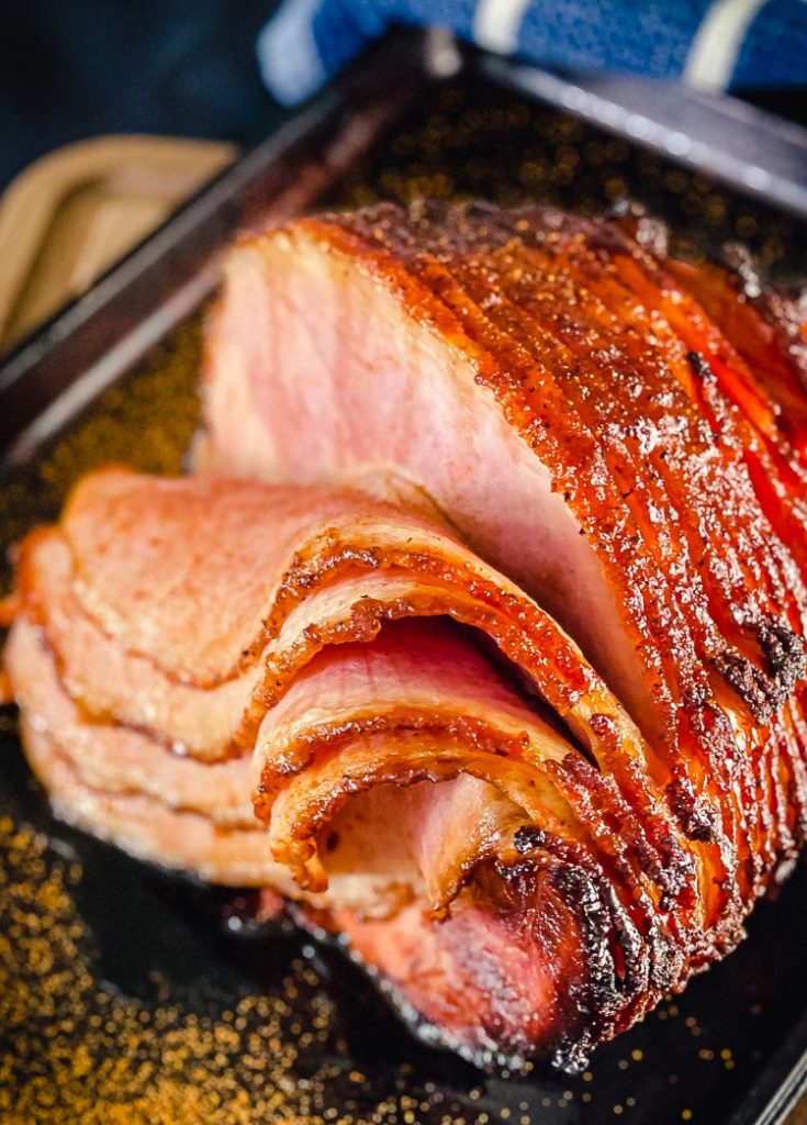sliced glazed ham on baking sheet