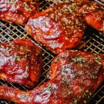 grilled chicken quarters on a cooling rack garnished with parsley